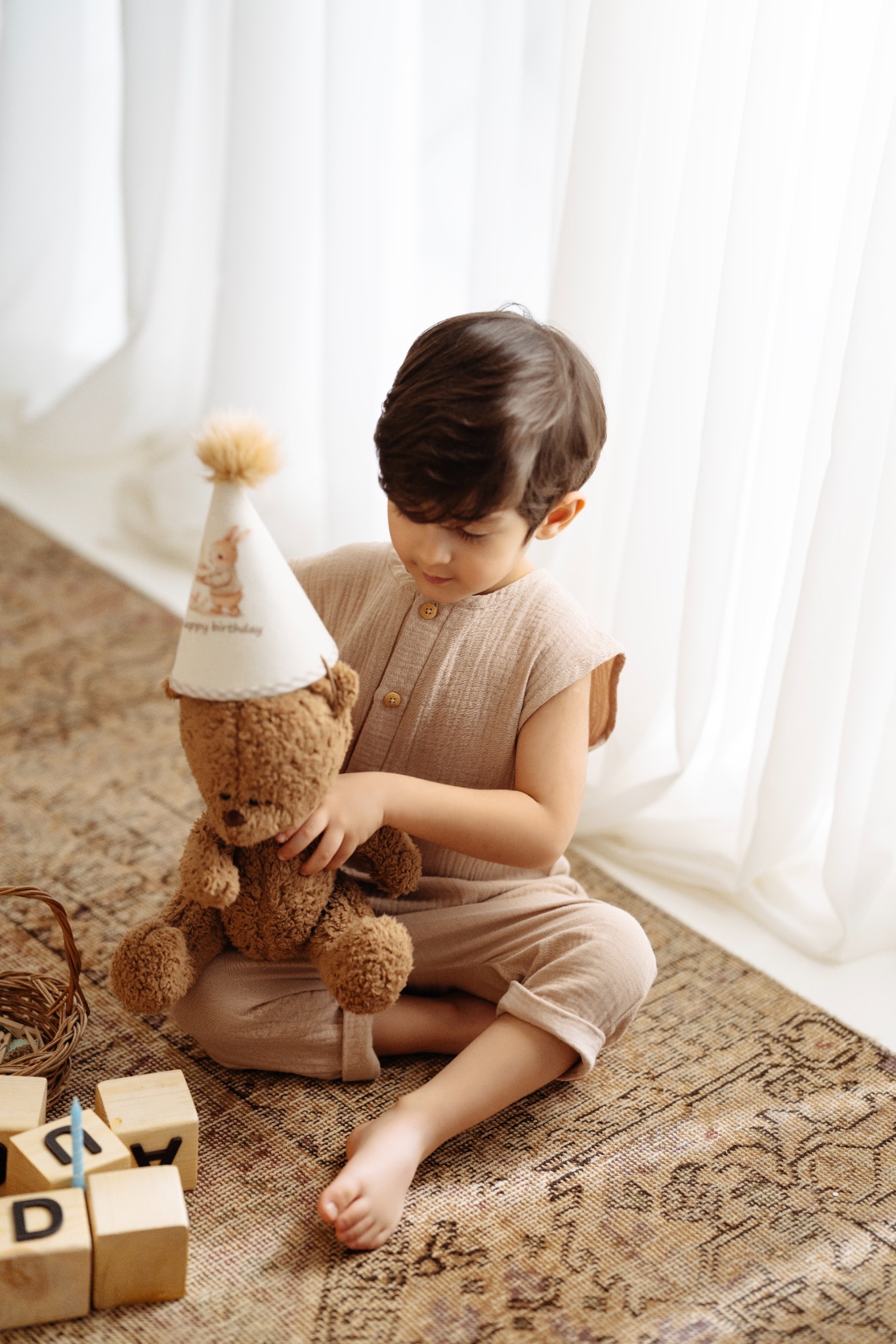 کودک با خرس و کلاه تولد